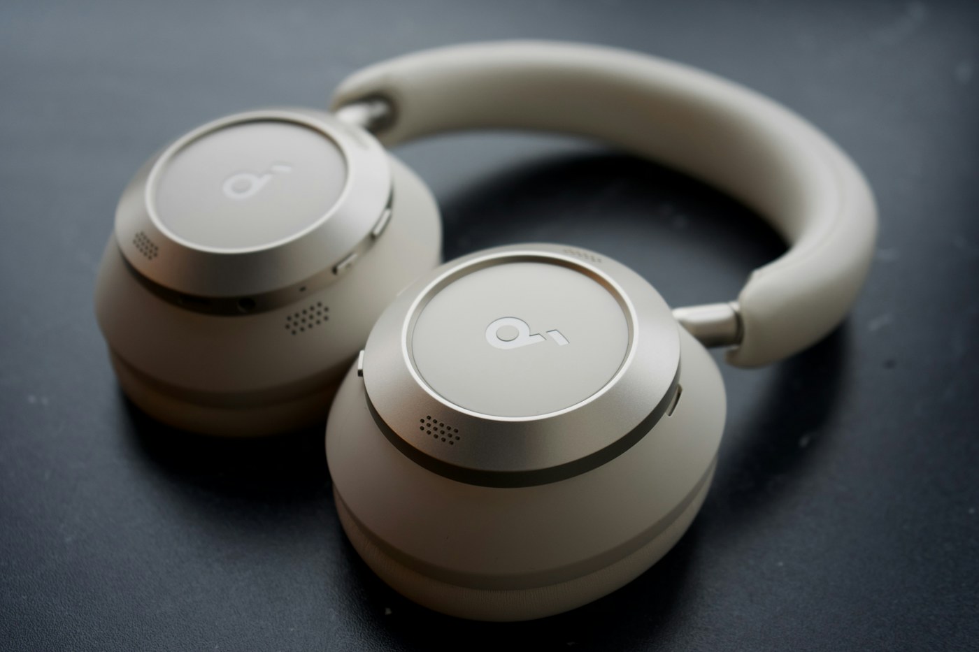 A pair of wireless over-ear headphones on a dark surface